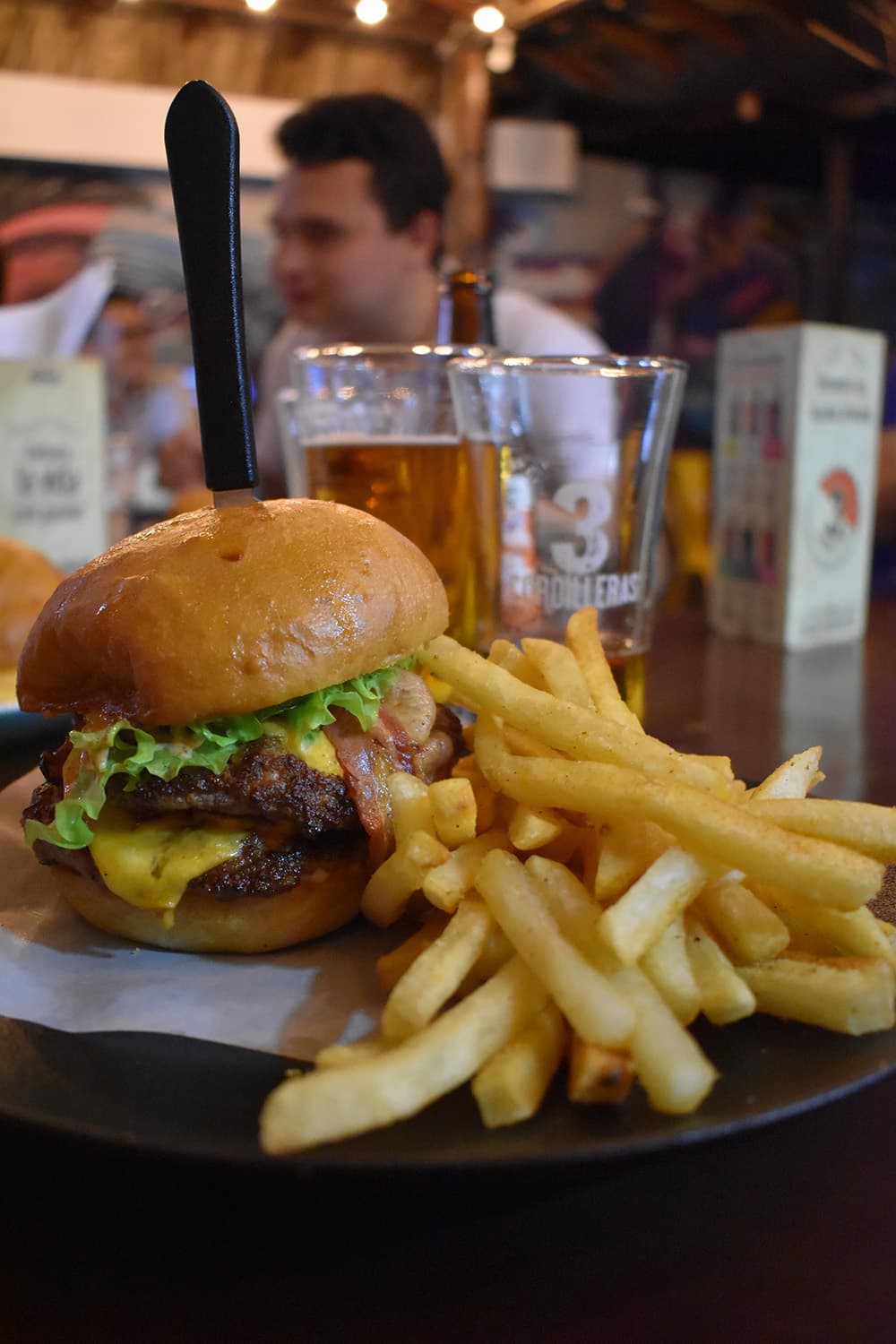 A juicy burger with cheddar cheese and bacon, accompanied by a side of crispy fries.