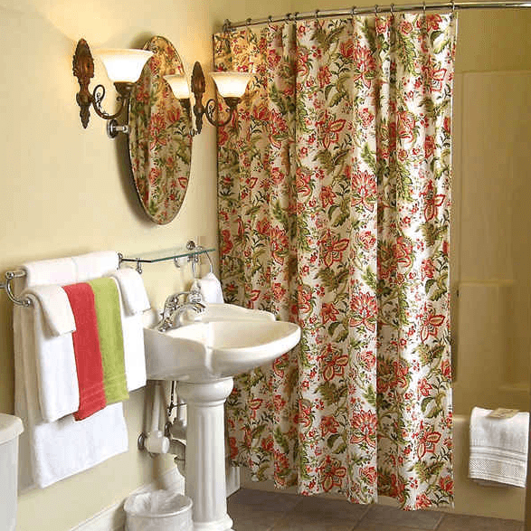Brightly decorated bathroom featuring a floral shower curtain, pedestal sink, and neatly arranged towels.