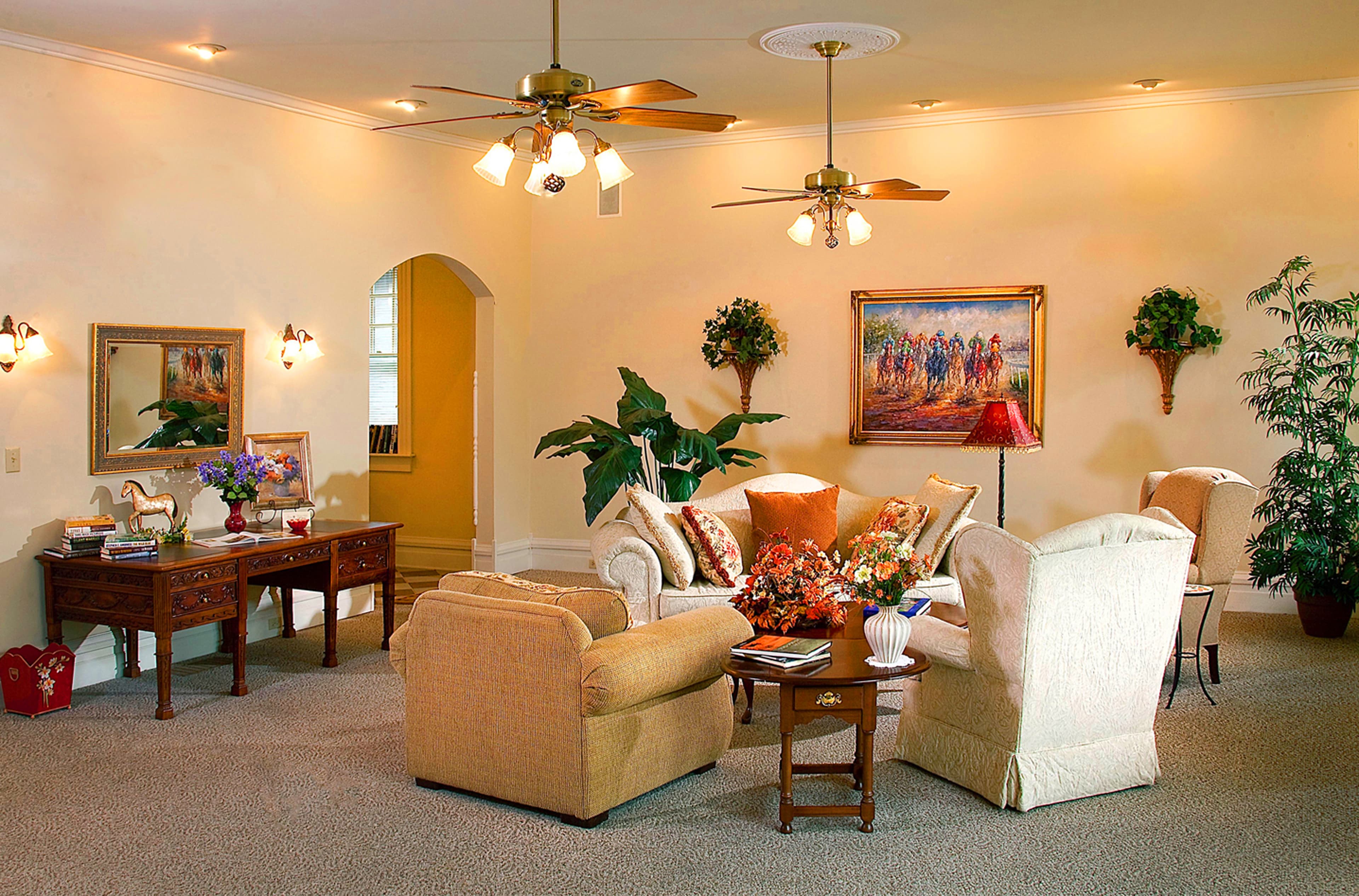 Cozy living room featuring comfortable seating, artwork, and decorative plants.